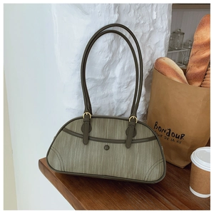 Détail du sac en cuir tressé vert olive avec baguette et café sur une table