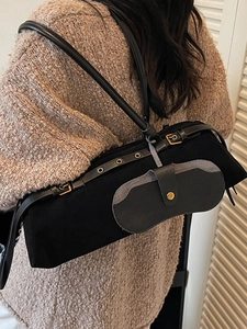 Minimalist black cylinder shoulder bag with adjustable strap and small side pouch