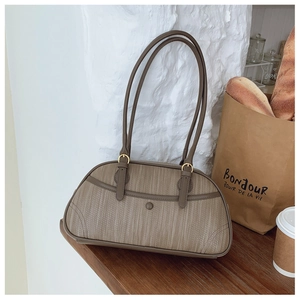 Détail du sac sous le bras marron rétro avec texture tissée et bandoulières en cuir lisse