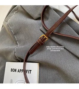 Detail of adjustable brown leather strap with golden buckle on a vintage handbag