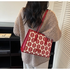 Detail of red tote bag with festive Chinese double joy pattern and slim leather strap