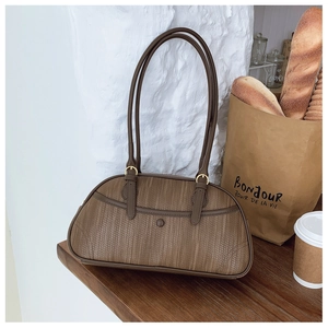 Gros plan sur la texture tressée du sac sous l'aisselle avec détails en cuir