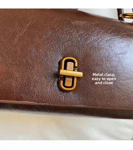 Detail of vintage bronze twist lock closure on premium brown leather handbag