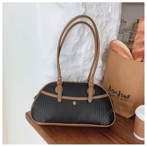 Détail du sac porté épaule tissé noir avec lanières en cuir marron et boucles dorées