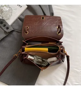 Top view of brown leather bag interior showing three compartments and large capacity