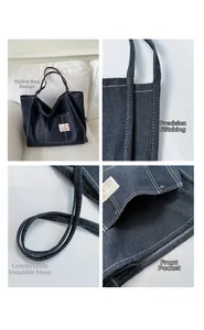 Detail view showing durable white stitching and front pocket on navy denim tote bag