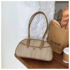 Vue détaillée du sac à bandoulière en cuir marron avec texture verticale et sangle