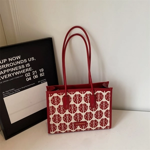 Detail view of red and beige woven tote bag with Chinese character pattern for weddings