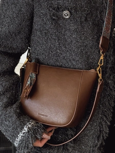 Brown leather bucket bag with vintage wide strap and decorative silk scarf detail