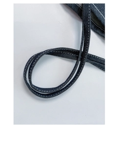 Close-up of deep blue denim tote bag shoulder strap with white contrast stitching detail