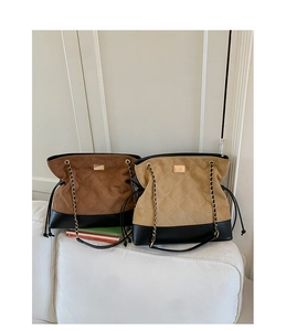 Close-up of vintage quilted tote bags in brown and beige with gold chain straps