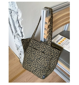 Gros plan sur le sac fourre-tout en toile léopard avec étiquette tissée et poche plaquée