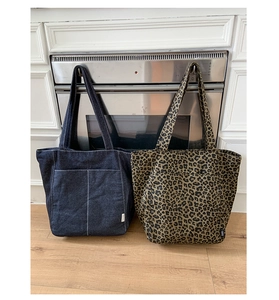 Détail des sacs cabas en toile denim et imprimé léopard avec design spacieux ouvert