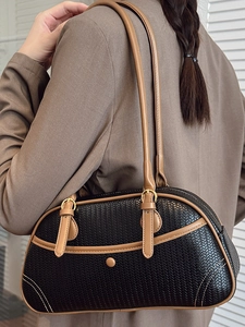 Sac à bandoulière tressé rétro avec garniture en cuir marron et boucles dorées sur modèle