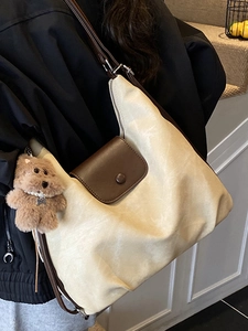 Minimalist beige tote bag with brown leather strap and cute bear charm shown on model