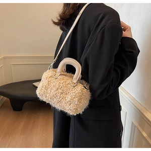 Close-up of beige fuzzy lamb wool Boston bag texture with smooth leather straps