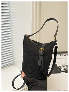 Détail du sac seau matelassé noir avec finition mate et fermeture éclair dorée élégante