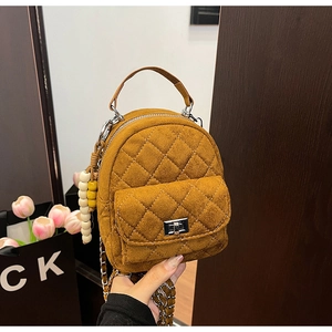Détail du sac à dos matelassé caramel avec chaîne argentée et breloque en perles