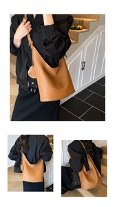 Detail view of khaki pebbled leather shoulder bag with matching round mini charm pouch