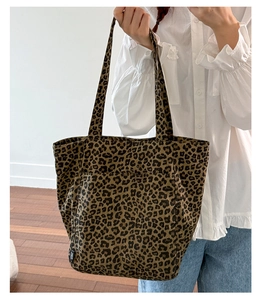 Gros plan sur le sac fourre-tout en toile imprimé léopard avec de longues anses d'épaule