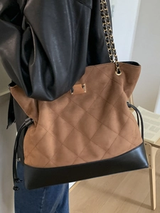 Quilted brown suede bucket bag with gold chain strap and black leather base details