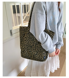 Vue détaillée du grand sac cabas en toile à imprimé léopard porté à l'épaule