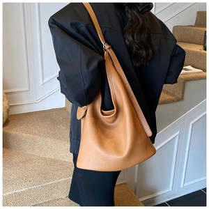Detail of adjustable strap and lychee grain leather texture on the caramel hobo bag