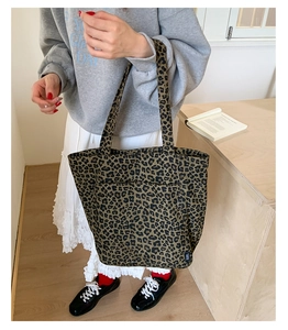 Gros plan d'un grand sac cabas en toile à motif léopard porté par un mannequin