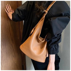 Brown lychee leather hobo bag for women shown as a side shoulder carry detail