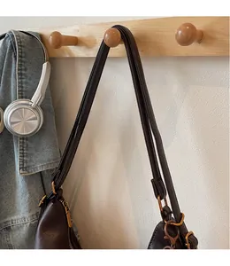 Detail of the smooth long brown leather straps with polished gold metal buckles