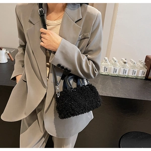 Detail of black faux fur plush crossbody bag with leather handle and silver hardware