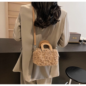 Detail of plush khaki Boston bag showing leather handles and adjustable shoulder strap
