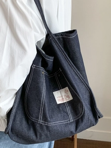Large capacity navy blue denim tote bag with white contrast stitching and woven label