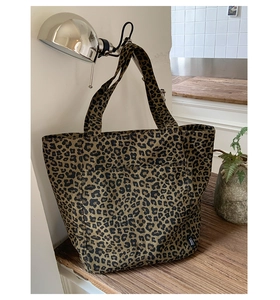 Détail du grand sac cabas en toile à imprimé léopard avec texture durable et étiquette tissée