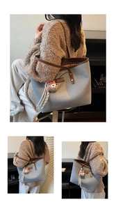 Blue canvas tote bag with brown leather trim and a cute sheep plush charm detail