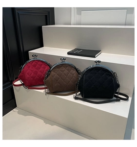 Three elegant quilted shell bags in red, brown, and black velvet on a podium display