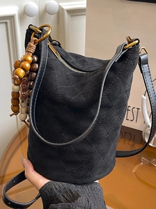 Sac seau matelassé en daim noir avec pendentif en perles de bois et bandoulière fine