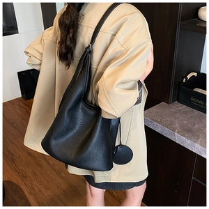 Close-up of black litchi pattern leather bucket bag with matching round coin purse