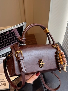 Classic vintage dark brown leather handbag with gold lock and colorful beaded tassel charm