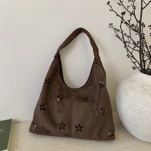 Detail shot of vintage dark brown suede tote bag with laser-cut floral hollow patterns