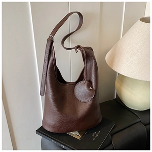 Close-up of premium lychee texture leather on deep brown bucket bag with strap