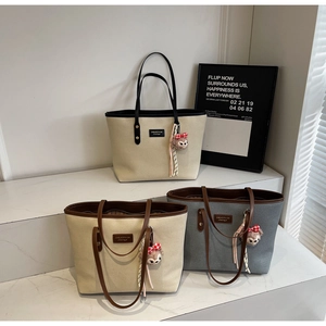 Detailed view of canvas tote bags in various colors with cute bear charms for daily commute
