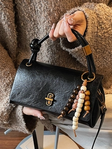 Classic black vintage crossbody bag with knotted handle and beaded charm accessory