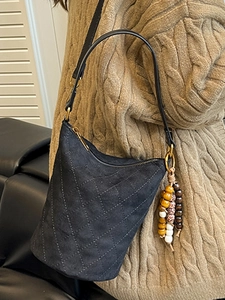 Sac seau matelassé noir avec pendentif en perles de bois et bandoulière pour femme