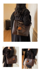 Detail view of large dark brown tote bag with bear charm showing commuter bag scale