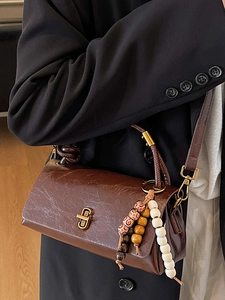 Classic vintage brown leather shoulder bag with glossy oil wax finish and ethnic wood beads
