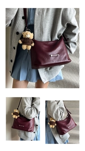 Detail view of burgundy faux leather tote bag with adjustable strap and cute bear charm