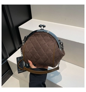 Detailed close-up of brown suede bag with quilted diamond stitching and metal clasp