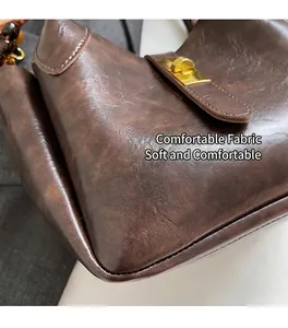 Detailed macro shot of vintage brown leather handbag with gold metal twist lock buckle