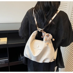 White hobo style backpack in soft PU leather with cute sheep pendant shown on model